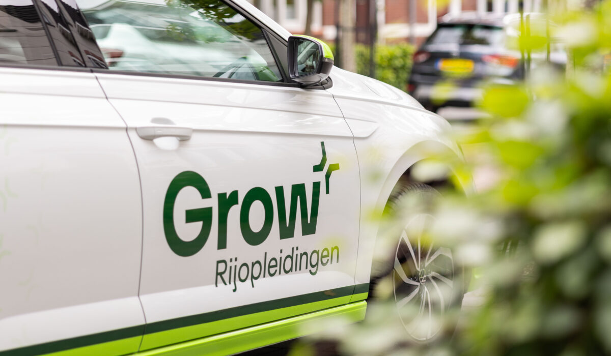 Lesauto van Grow Rijopleidingen geparkeerd in een woonwijk